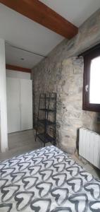 ein Schlafzimmer mit einer Steinmauer und einem Bett in der Unterkunft APARTAMENTO EN EL CASCO HISTÓRICO DE PLENTZIA II in Plentzia