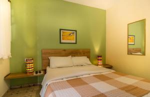 a bedroom with a bed and a green wall at Hotel Fazenda Canto da Serra in Jaconé