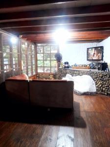 a living room with a couch and a bed at Cabaña Altos de San Carlos in Santa Marta
