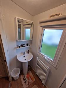 a bathroom with a sink and a window at Pride caravan in Rhyl