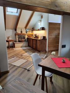 cocina y comedor con mesa de madera y sillas en A casa da Elide, en Aymavilles