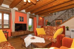 a living room with a couch and a tv at VILLA SALVIA - Holiday house with pool - in Jurdani
