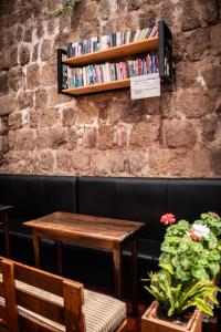 una mesa y un estante de libros en una pared de ladrillo en Intro Hostels Cusco, en Cusco