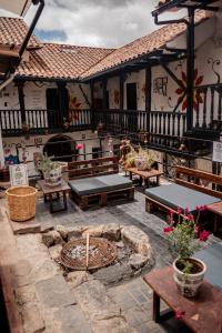 an outdoor patio with benches and a fire pit at Intro Hostels Cusco in Cusco
