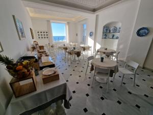 ein Restaurant mit Tischen und Stühlen in einem Zimmer in der Unterkunft Hotel Miramare in Spotorno