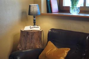 a lamp sitting on a stump next to a couch at Agritur Maso Carpenè in Rovereto