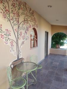 a room with a table and chairs and a tree painted on the wall at Hacienda De Palmas in La Ribera