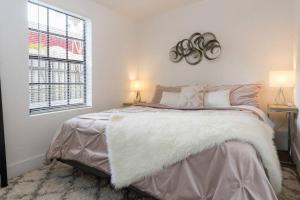 a bedroom with a bed with a white blanket and a window at Lovely Apartment Near Brickell 1 in Miami