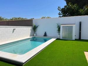 un cortile con piscina e prato verde di Villa Zen, La Barrosa a Cadice
