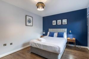 1 dormitorio con 1 cama grande y paredes azules en ** Modern Merchant City 1 BED Apartment with Free Parking **, en Glasgow