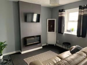 a living room with a couch and a fireplace at 16 Main Street in St Bees