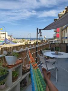 une personne allongée dans un hamac sur un balcon dans l'établissement T2 cosy à la plage, terrasse vue sur mer et parking privatif, à Narbonne