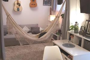 un hamac dans une pièce avec un bureau et une guitare dans l'établissement T2 cosy à la plage, terrasse vue sur mer et parking privatif, à Narbonne 17 autres photos