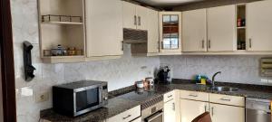 a kitchen with white cabinets and a microwave at BAYAMO 2 in Vigo