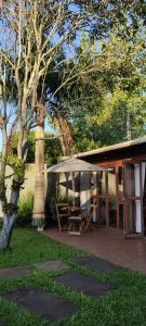 une terrasse avec une tente, une table et un arbre dans l'établissement Pousada Águas do Mampituba, à Torres