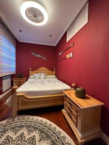 a bedroom with a bed and a red wall at Madera de Olmo in Madrid