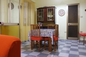 Casa Vacanze Nonna Franca في كابراس: غرفة طعام مع طاولة وبعض الكراسي