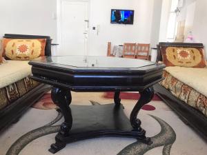 une table noire dans une pièce avec deux canapés dans l'établissement Appartement Familial en face le grand stade de tanger, à Tanger 2 autres photos