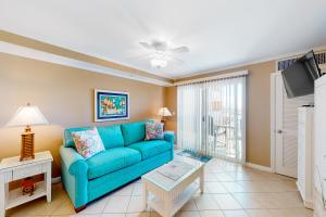 a living room with a blue couch and a flat screen tv at Makai 403 in Ocean City