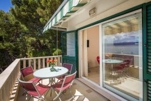 un patio con tavolo e sedie sul balcone. di Villa Adriatica Excelsior - Beachfront Retreat a Stanići