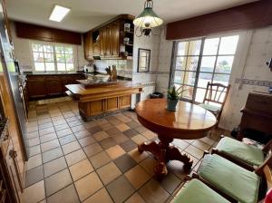 a kitchen with a wooden table and a tableasteryasteryasteryasteryasteryasteryastery at Mar De Frisia in O Pino 