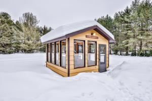 um pequeno edifício com um telhado coberto de neve na neve em Echo Lodge em Mercer