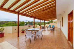 een overdekte patio met een tafel en stoelen en uitzicht bij Hotel Villa Laguna in Puerto Ayora