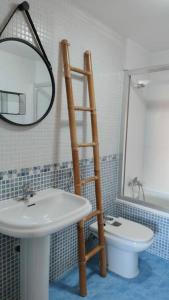 a bathroom with a ladder next to a toilet and a sink at Apartamento La Emisora in Ponferrada