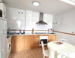 cocina con mesa, fregadero y fogones en Apartamento La Emisora en Ponferrada