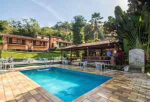 uma piscina em frente a uma casa em Hotel Fazenda Canto da Serra em Jaconé