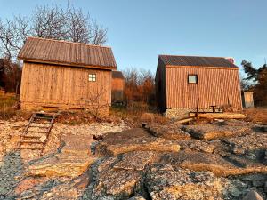 a couple of barns and a dog on some rocks at Högklint Rövar Liljas Apartment in Visby