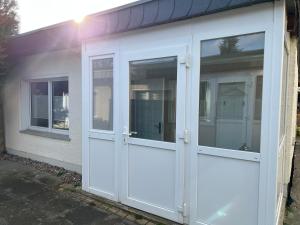 eine weiße Garagentür mit zwei Fenstern an einem Haus in der Unterkunft Banana Jack Boltenhagen in Boltenhagen