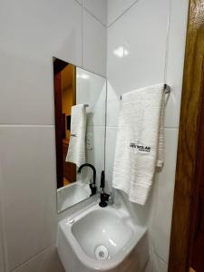 a white bathroom with a sink and a mirror at Pousada Vento Solar Búzios in Búzios