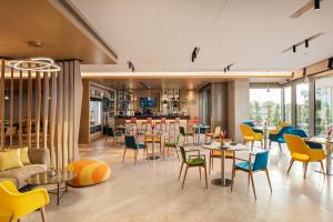 un ristorante con tavoli e sedie e un bar di Holiday Inn & Suites - Dubai Science Park, an IHG Hotel a Dubai
