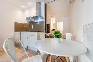 a kitchen and dining room with a white table and chairs at Loft Planta Baja en Barri Port Maritim in Tarragona