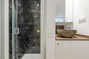 a bathroom with a sink and a glass shower at Loft Planta Baja en Barri Port Maritim in Tarragona