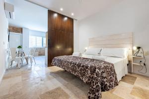a bedroom with a large bed and a table and chairs at Loft Planta Baja en Barri Port Maritim in Tarragona