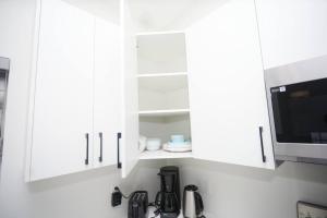 a kitchen with white cabinets and a microwave at Comfortable home near airport in Winnipeg