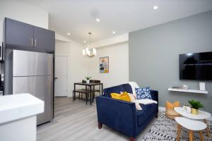 Una sala de estar con un sofá azul y una cocina. en Comfortable home near airport, en Winnipeg