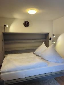 ein Schlafzimmer mit einem Bett mit einer Uhr an der Wand in der Unterkunft Mellex FeWo in Feldberg
