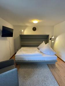 a bedroom with a bed and a couch and a clock at Mellex FeWo in Feldberg
