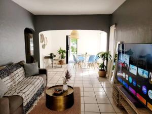 een woonkamer met een bank en een flatscreen-tv bij LITTLE HAVANA/CALLE OCHO 3 - BEST APARTMENT in Miami