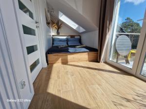 a bedroom with a bed and a large window at Bursztynowe Międzywodzie in Międzywodzie