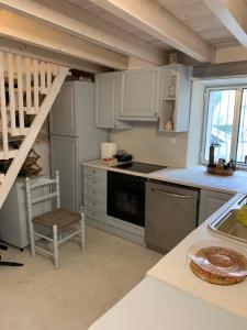 une cuisine avec des placards blancs et un escalier dans l'établissement Grandma’s stone-house, à Amphilochie