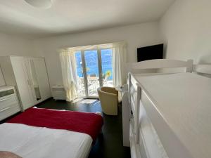 1 dormitorio con 2 camas y vistas al océano en Hotel Garni Morettina en Brissago