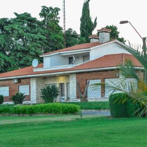 una gran casa de ladrillo con techo rojo en Posada de Campo San Cono, en Mercedes