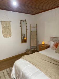 1 dormitorio con cama y espejo en la pared en Casa de campo a 5 min de Vigo en Mos