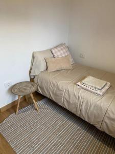 a bed in a room with a table next to it at Casa de campo a 5 min de Vigo in Mos