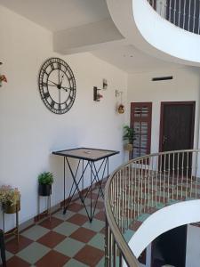 une chambre avec une table et une horloge sur le mur dans l'établissement Bethel Service Villa, Mananthavady, Wayanad, à Wayanad