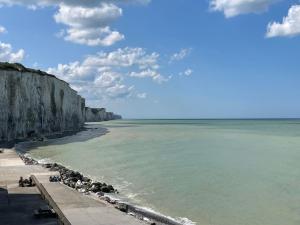 a view of a beach with rocks and the ocean at L'Opaline-Maisonnette 28m2 grand confort avec jardin-tout inclus in Tully